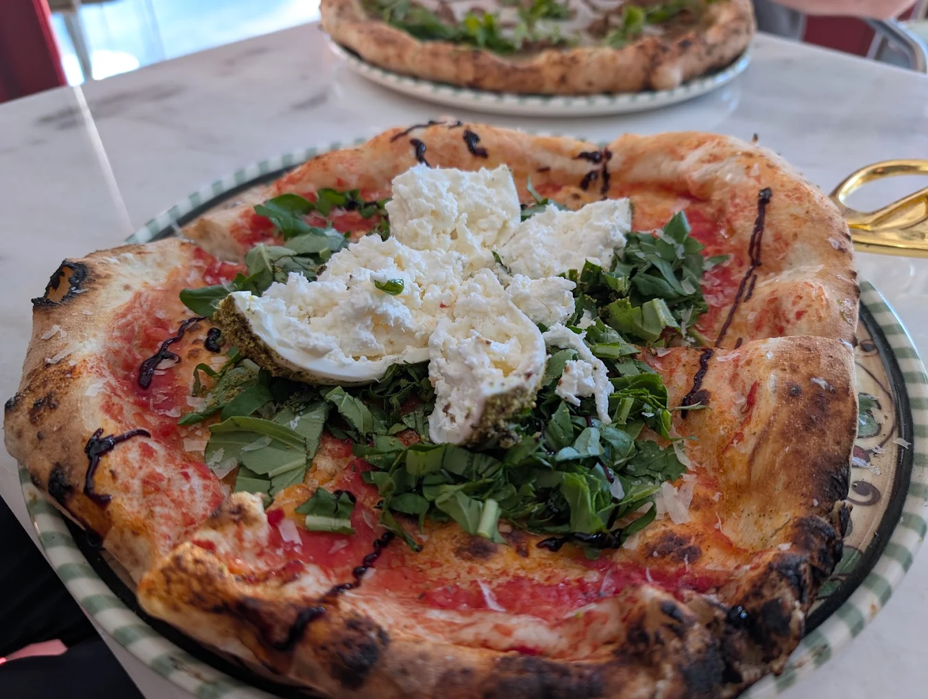 Burrata, roka ve fesleğen ile hazırlanan il Bello pizzası